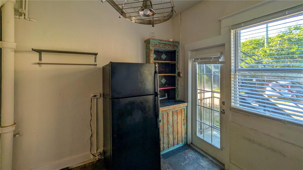 A kitchen features a black refrigerator, a rustic wooden cabinet, and a glass-paned exterior door — 610 4TH AVENUE S, ST PETERSBURG, FL