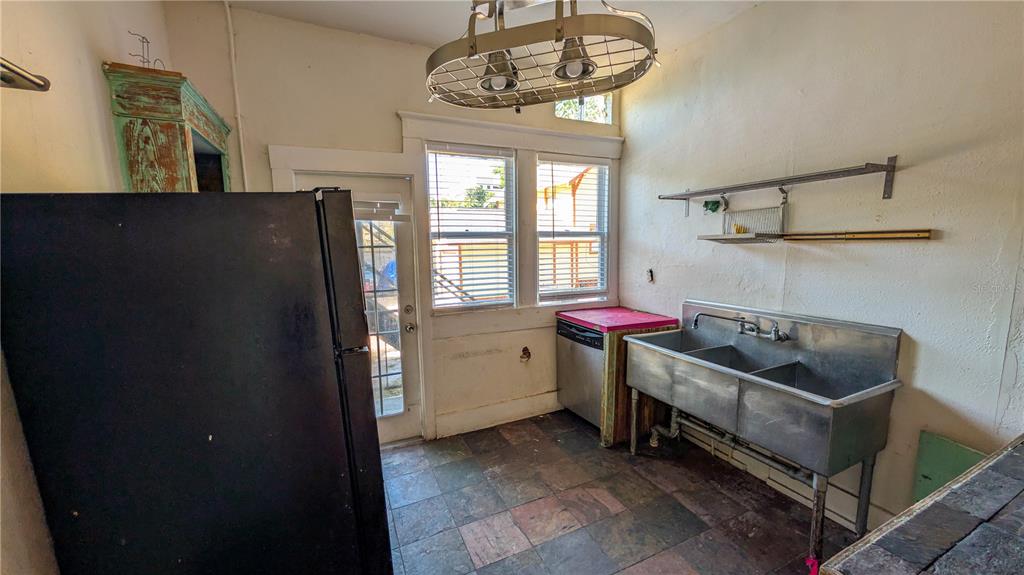 A kitchen features a black refrigerator, a stainless steel utility sink, and a dishwasher — 610 4TH AVENUE S, ST PETERSBURG, FL