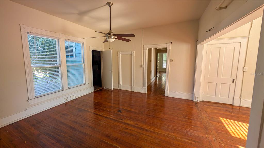 An empty room with hardwood floors, a ceiling fan, and multiple doorways — 610 4TH AVENUE S, ST PETERSBURG, FL