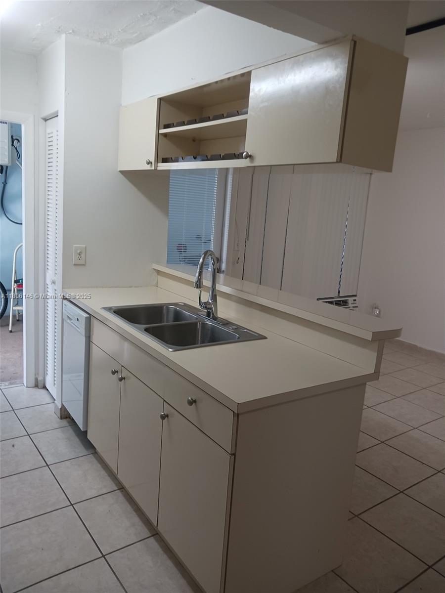 A kitchen features light-colored cabinets, a double-basin stainless steel sink, and tiled flooring — 2700 NE 135th St # 30, North Miami FL 33181, NORTH MIAMI, FL