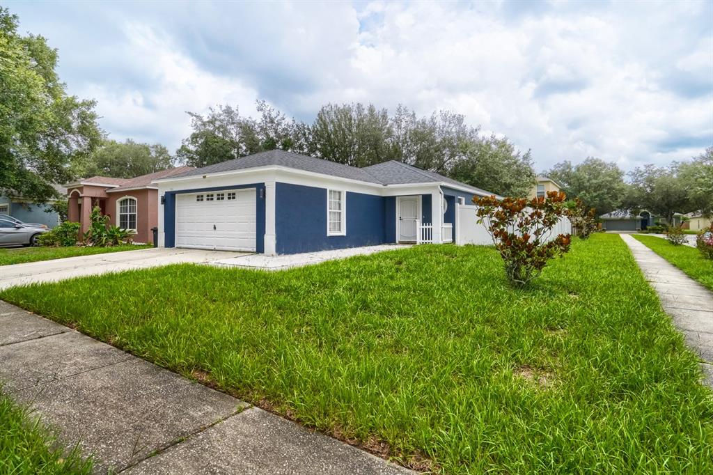 A single-story house with a blue exterior, white trim, and a two-car garage — 701 PERIWINKLE POINTE PLACE, SEFFNER, FL
