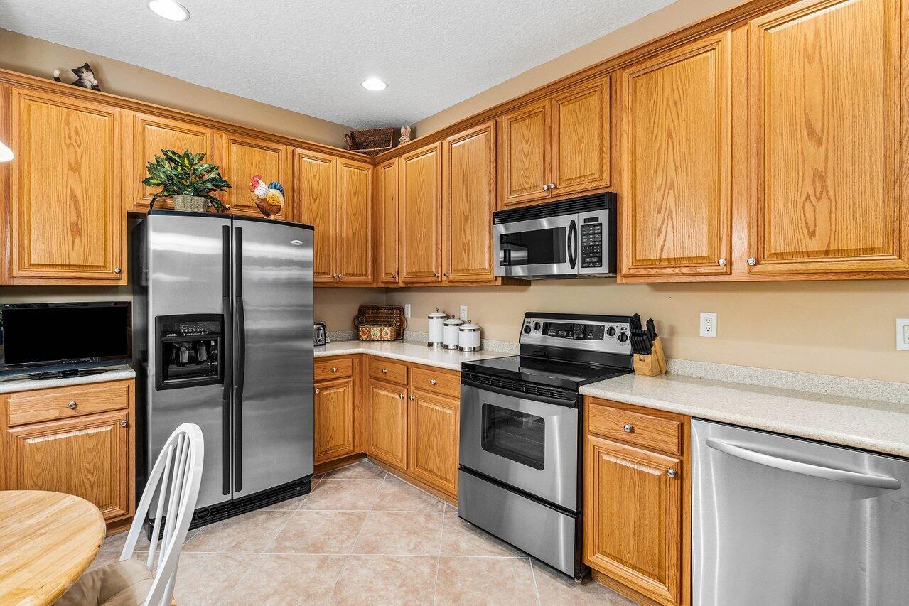 A kitchen with oak cabinets, stainless steel appliances, and light-colored countertops — 23069 Addison Lakes Circle, Boca Raton FL 33433, BOCA RATON, FL
