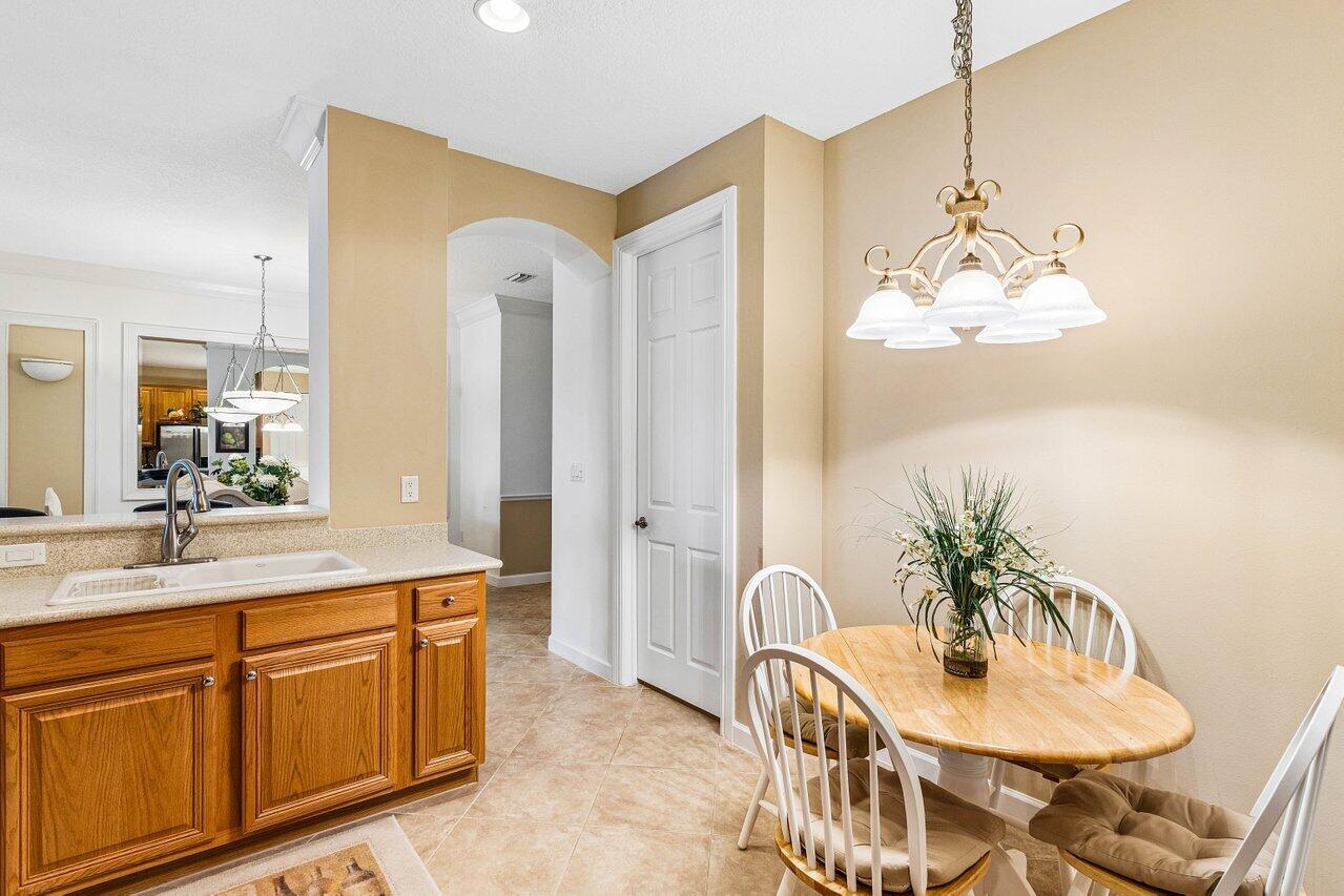 A kitchen breakfast nook features light wood cabinets, a dining table, and a chandelier — 23069 Addison Lakes Circle, Boca Raton FL 33433, BOCA RATON, FL