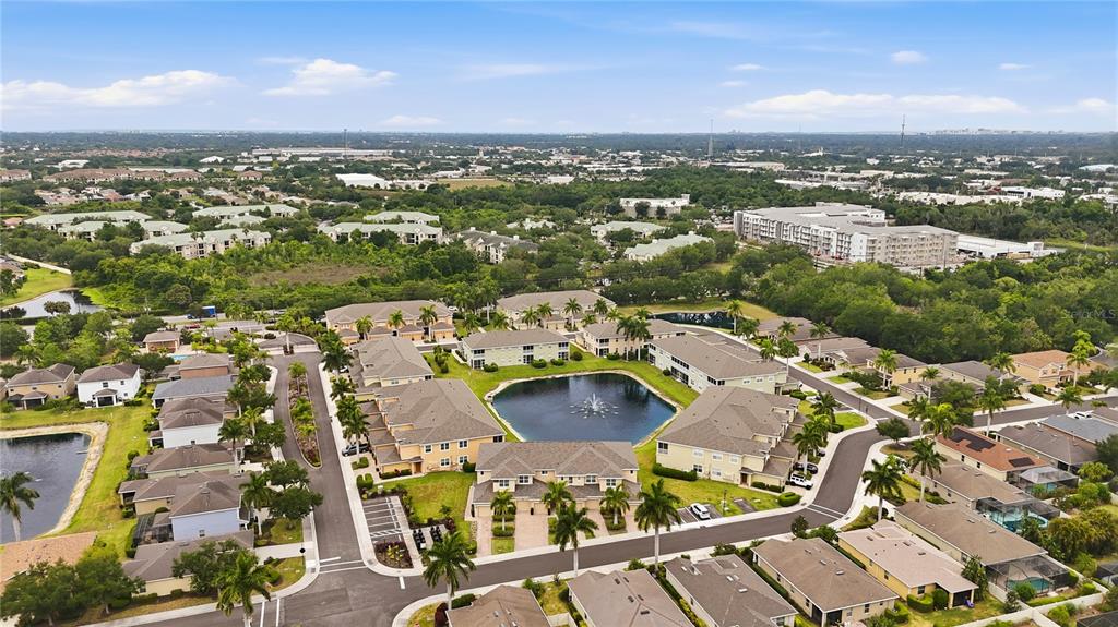 An aerial view shows a residential community with multi-story buildings surrounding a central pond — 8423 KARPEAL DRIVE UNIT 1501, SARASOTA, FL