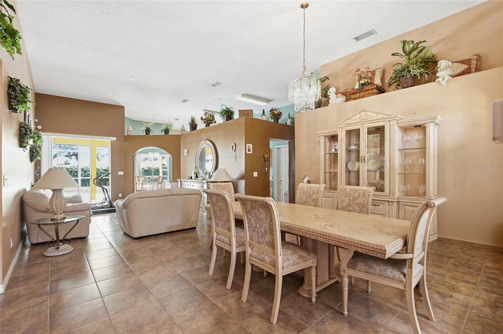 A dining area with a large hutch and table sits adjacent to a living room — 9602 SUNNYOAK DRIVE, RIVERVIEW, FL