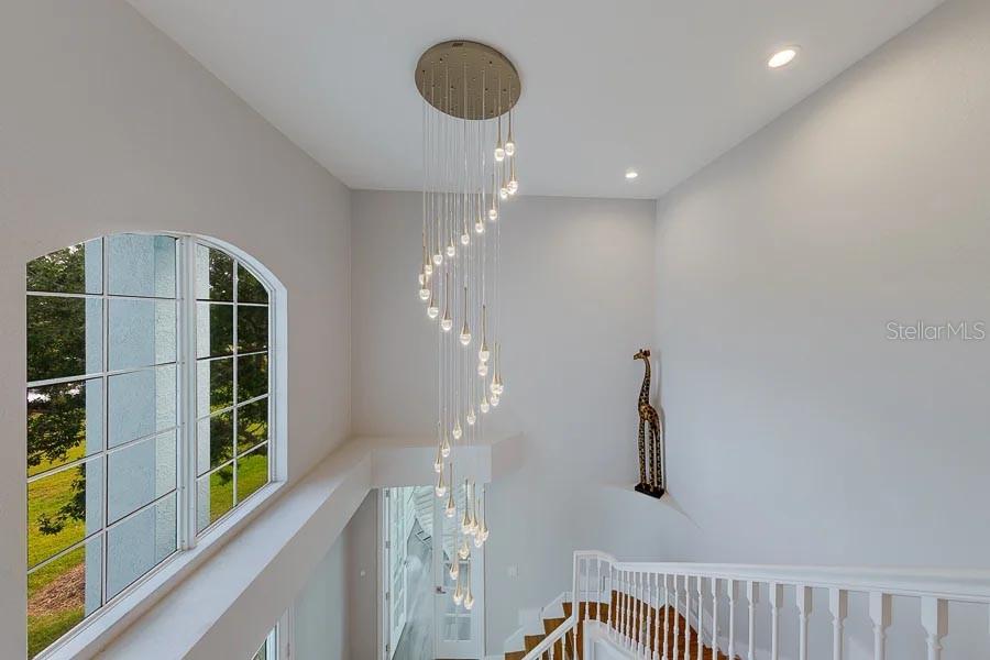 A light blue, three-story house with two garage doors and a concrete driveway — 2106 PELICAN COURT, TARPON SPRINGS, FL
