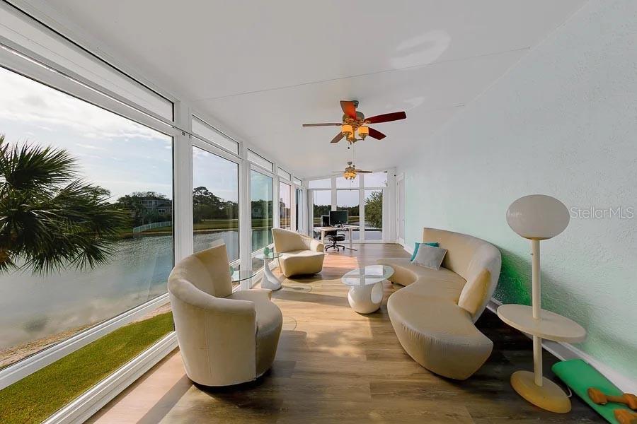 A light blue elevated house features a white staircase leading to the front entrance — 2106 PELICAN COURT, TARPON SPRINGS, FL