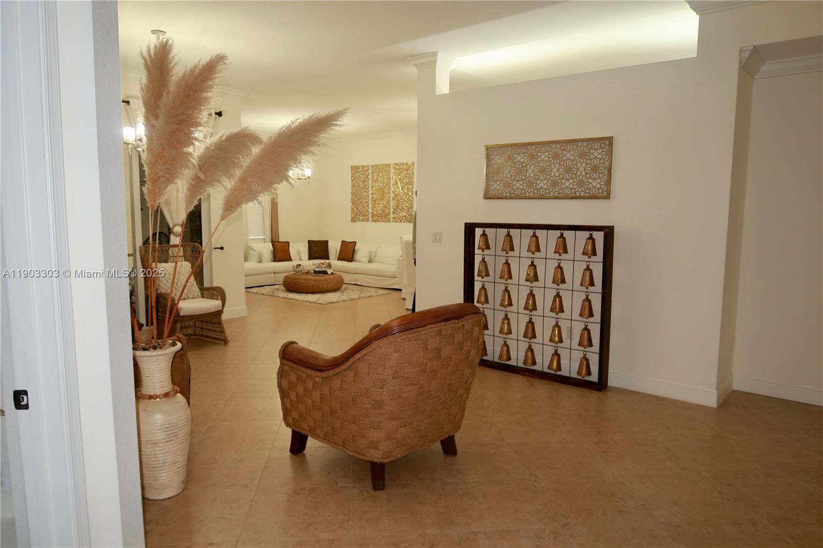 A living room features a wicker chair, a bell display, and a white sofa — 9778 Bowline Drive # 102, West Palm Beach FL 33411, WEST PALM BEACH, FL