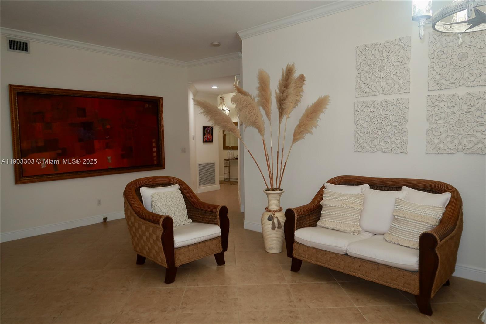A living area features a wicker chair and loveseat, a large painting, and decorative wall panels — 9778 Bowline Drive # 102, West Palm Beach FL 33411, WEST PALM BEACH, FL