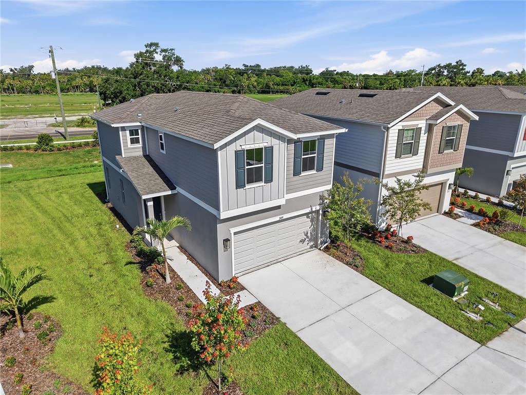 An aerial view shows two modern two-story suburban houses with gray siding and concrete driveways — 2419 29TH LANE E, PALMETTO, FL