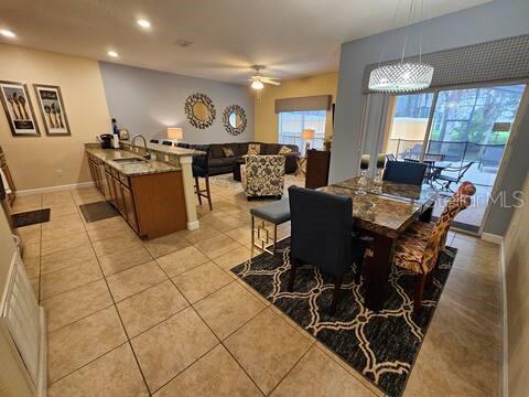 An open-concept kitchen and dining area features tile flooring, a breakfast bar, and patio access — 2945 BANANA PALM DRIVE, KISSIMMEE, FL