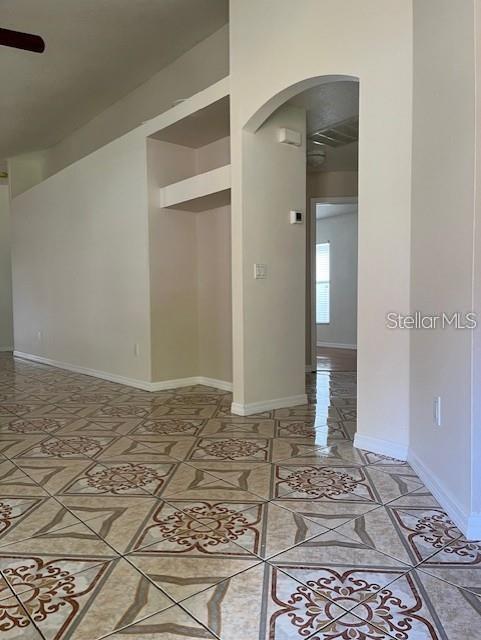 An interior view shows a tiled floor, a built-in wall niche, and an arched doorway — 8434 QUARTER HORSE DRIVE, RIVERVIEW, FL