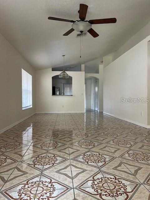 An open living area features vaulted ceilings, a ceiling fan, and patterned tile flooring — 8434 QUARTER HORSE DRIVE, RIVERVIEW, FL