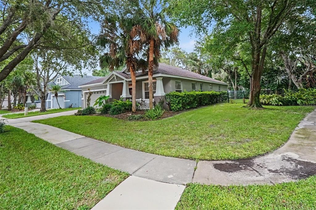 A single-story house with a gray exterior, a two-car garage, and palm trees in front — 15536 GANNETGLADE LANE, LITHIA, FL