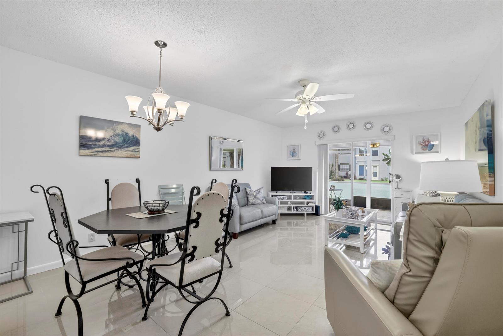 A bright, open-concept living and dining area features white walls, tile flooring, and coastal decor — 5681 SW 2nd Court # 106, Margate FL 33068, MARGATE, FL