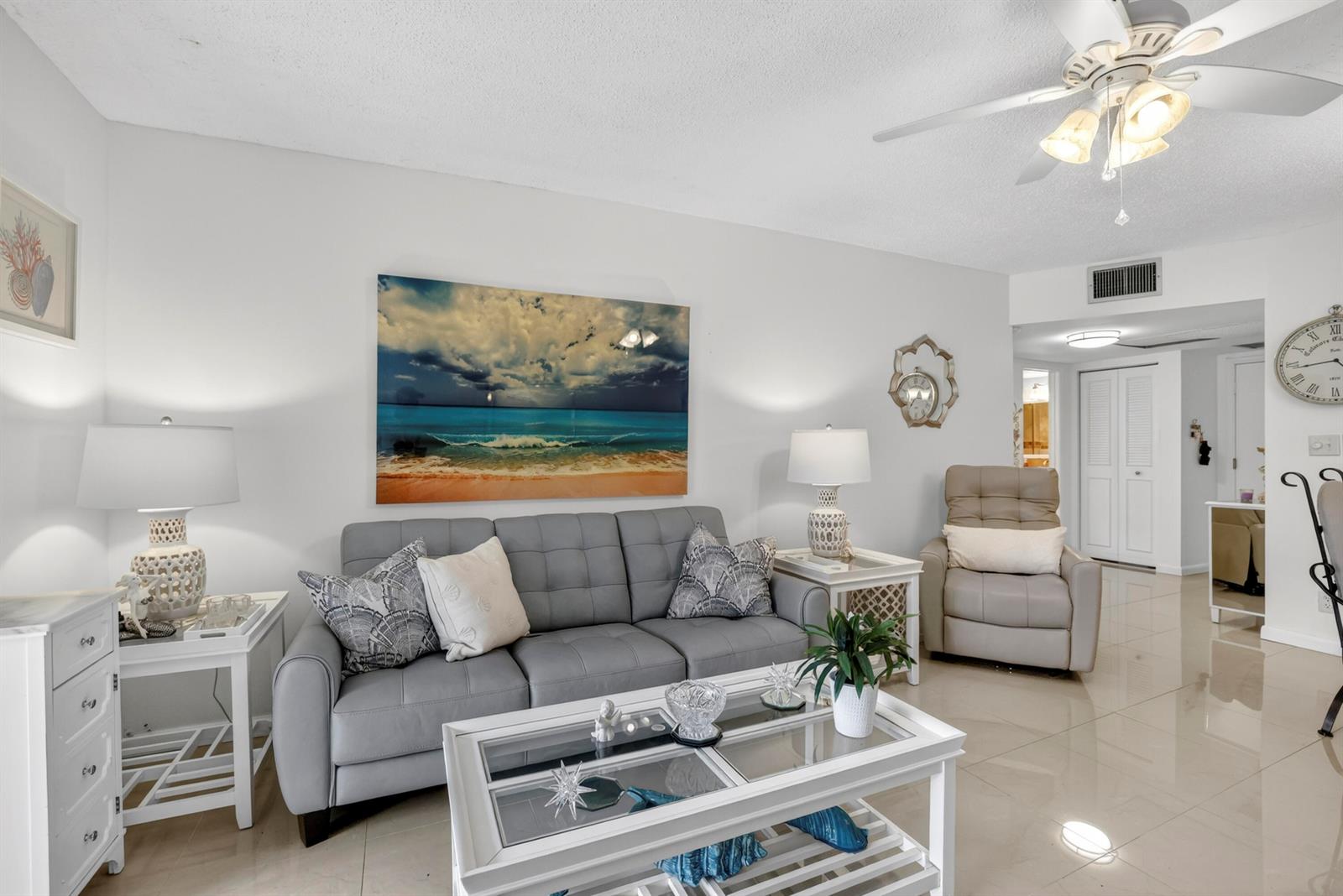 A living room features a gray sofa, a glass-topped coffee table, and a beige recliner — 5681 SW 2nd Court # 106, Margate FL 33068, MARGATE, FL