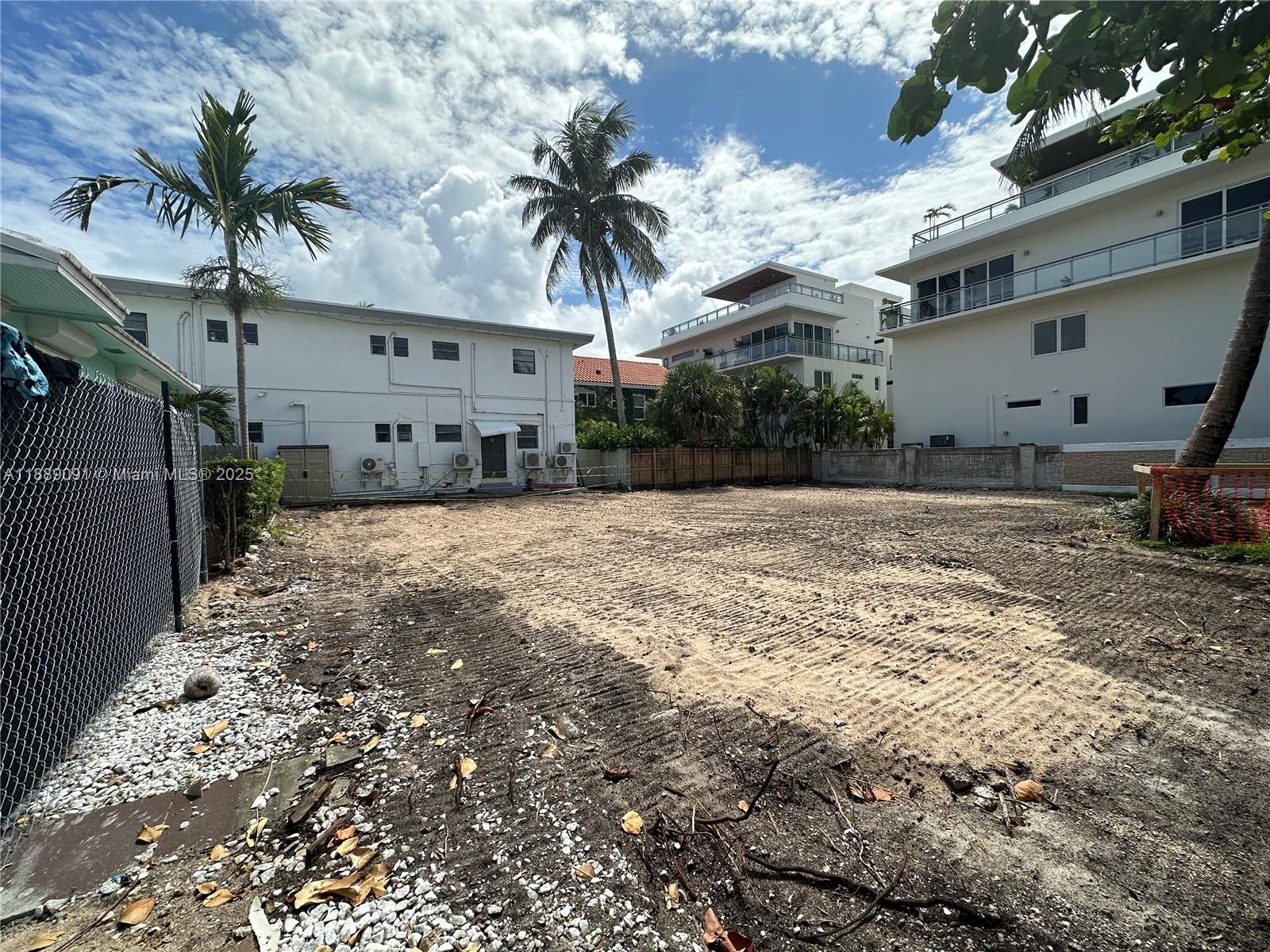 A vacant, cleared dirt lot sits between two multi-story residential buildings under a cloudy sky — 350 Walnut St, Hollywood FL 33019, HOLLYWOOD, FL