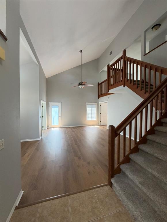 A bright living area features wood flooring, a vaulted ceiling, and a wooden staircase — 4308 KIPLING AVENUE, PLANT CITY, FL