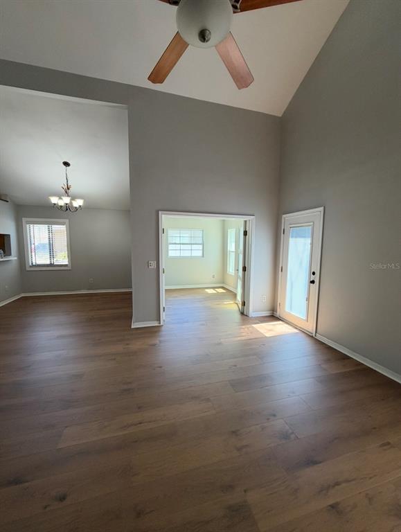 A living room with vaulted ceilings, wood-look flooring, and French doors leading to a room — 4308 KIPLING AVENUE, PLANT CITY, FL