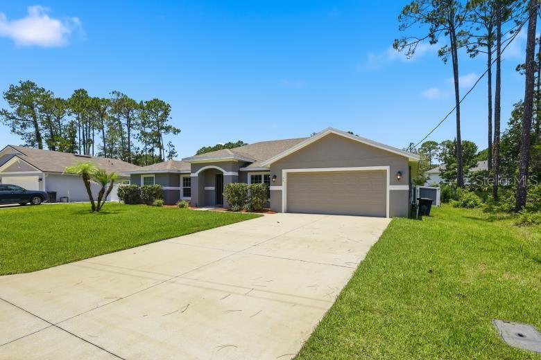 A single-story house with a gray exterior, a two-car garage, and a concrete driveway — 55 BENNETT LANE, PALM COAST, FL