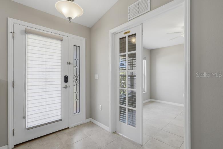 An entryway features a white front door with a sidelight and a glass-paned interior door — 55 BENNETT LANE, PALM COAST, FL