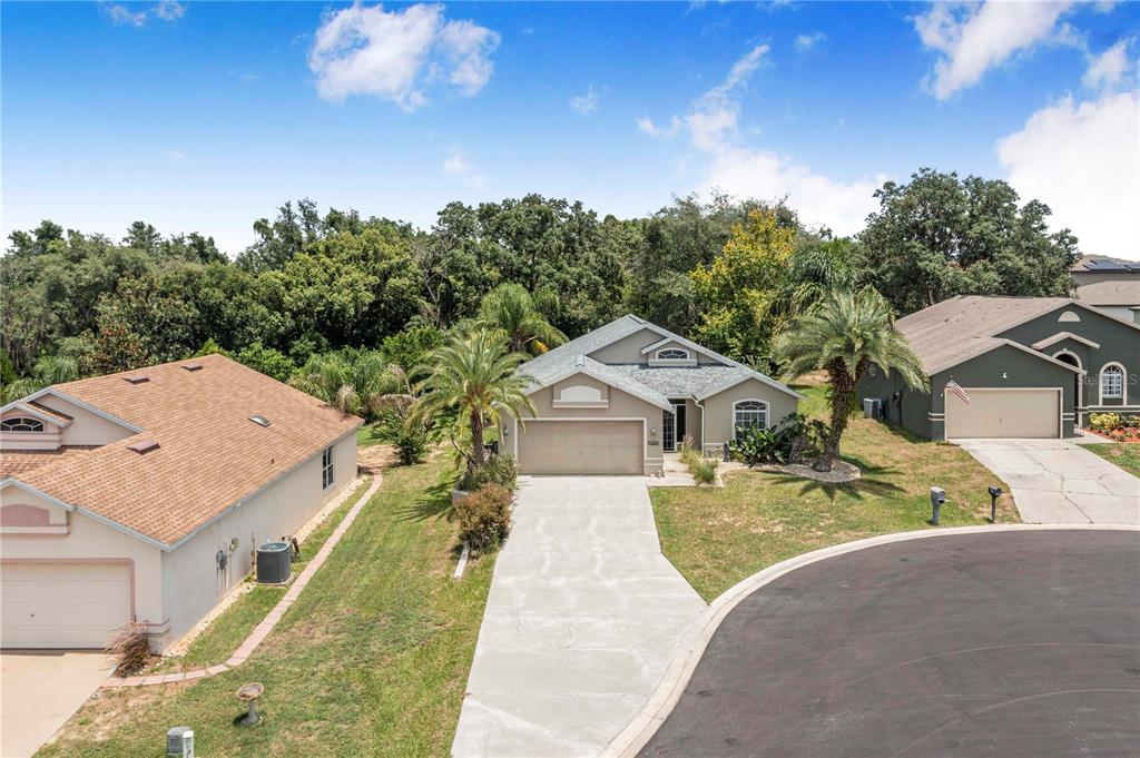 An aerial view shows a single-story suburban house with a concrete driveway and palm trees — 112 MONACO DRIVE, DAVENPORT, FL