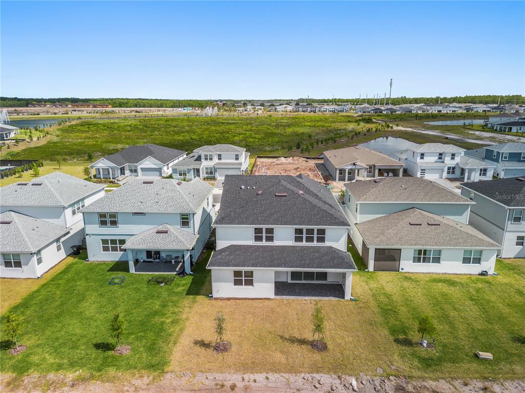 An aerial view shows the back of several suburban houses with lawns and a pond — 9662 PASSAIC PARKWAY, ORLANDO, FL