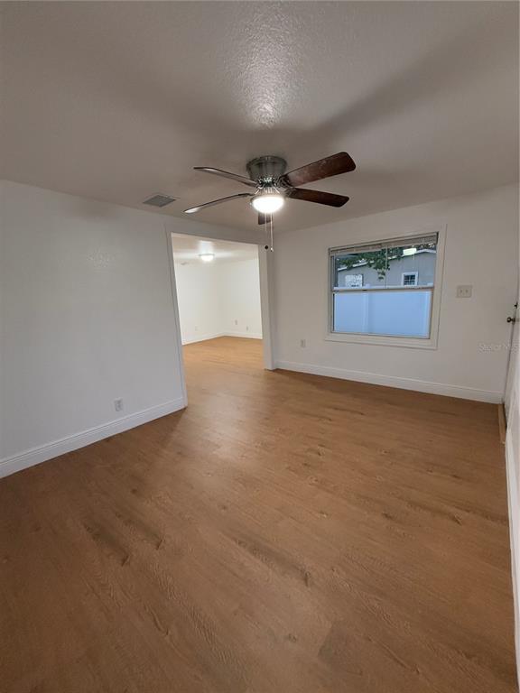 A room with light wood-look flooring, white walls, a ceiling fan, and a window — 636 COKE AVENUE, WINTER GARDEN, FL