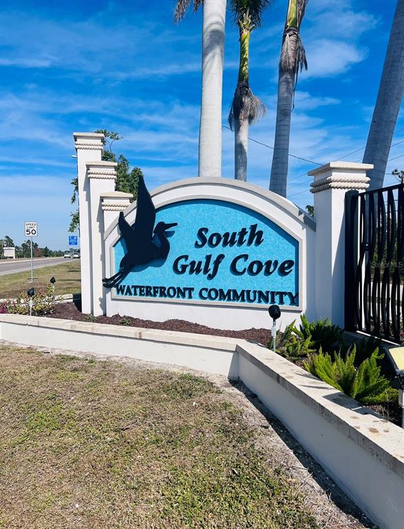 A sign for South Gulf Cove Waterfront Community stands near a road with palm trees — 15842 VISCOUNT CIRCLE, PORT CHARLOTTE, FL