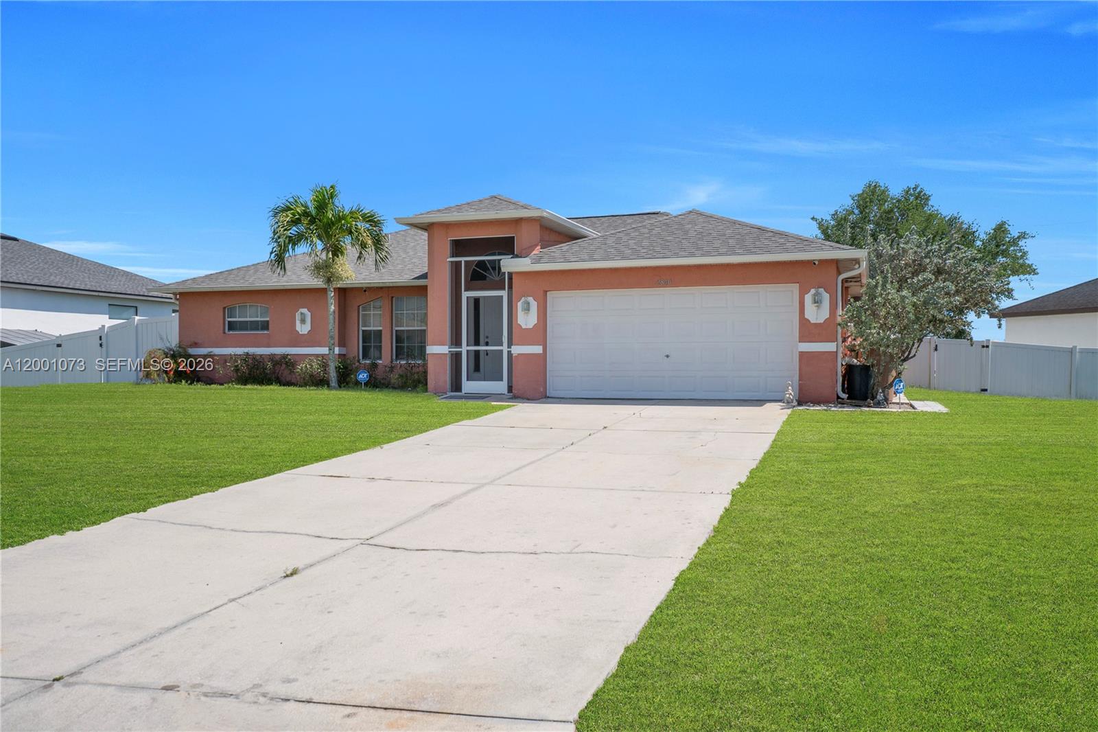 A single-story peach-colored house features a two-car garage, a concrete driveway, and a palm tree — 2840 NW 2ND TERRACE, Cape Coral FL 33993, CAPE CORAL, FL