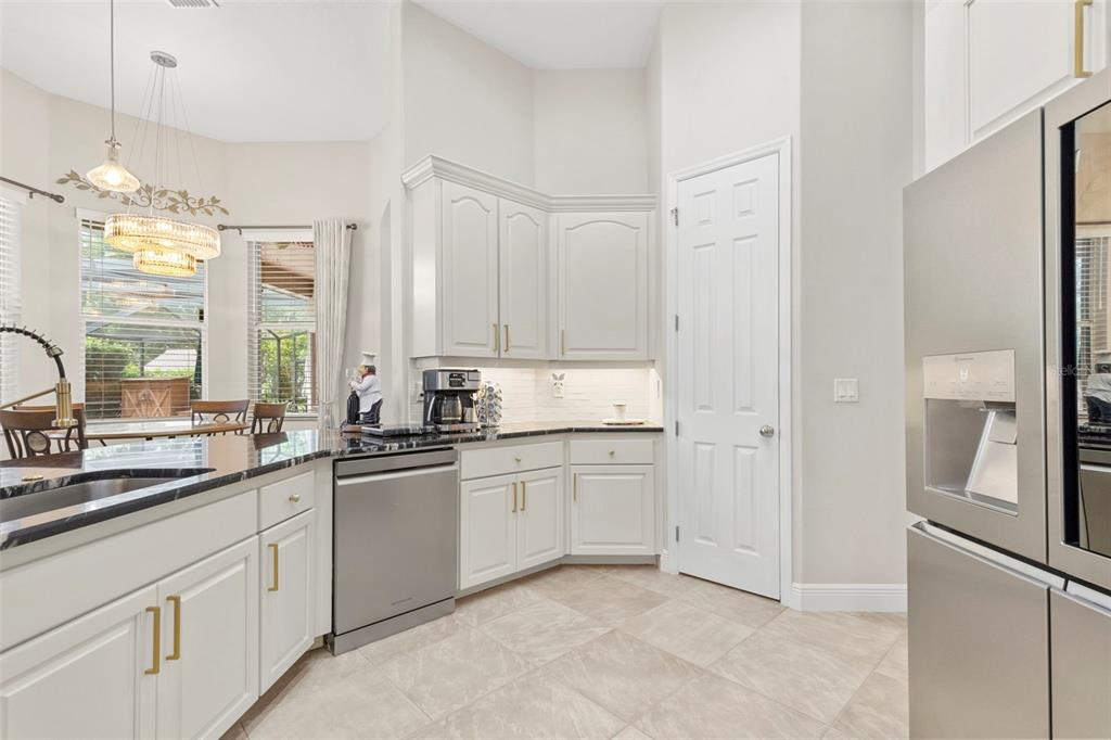 A kitchen features white cabinets, stainless steel appliances, granite countertops, and a tile floor — 20203 CANE RIVER WAY, TAMPA, FL