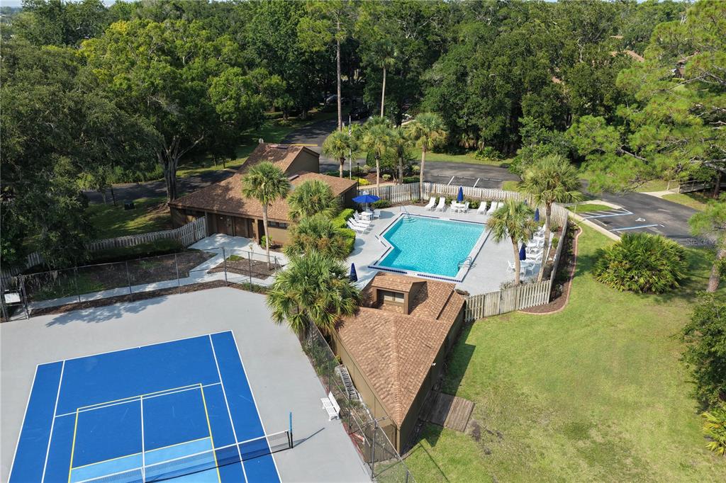 An aerial view shows a swimming pool, a tennis court, and a small clubhouse building — 37 HEMBURY LANE UNIT 37, PALM COAST, FL