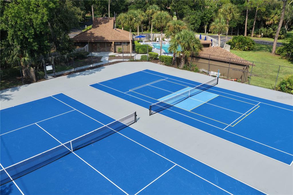 An aerial view of two blue tennis courts with nets and a nearby swimming pool — 37 HEMBURY LANE UNIT 37, PALM COAST, FL