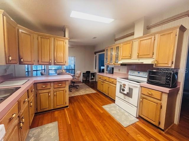A kitchen with light wood cabinets, pink countertops, and hardwood flooring — 7053 SPANISH MOSS LANE, BROOKSVILLE, FL