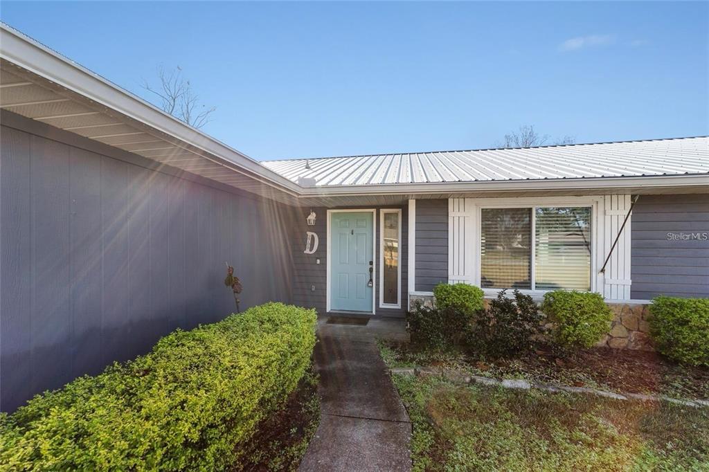 A light blue front door is centered on the exterior of a gray house — 2700 SE 35TH STREET, OCALA, FL