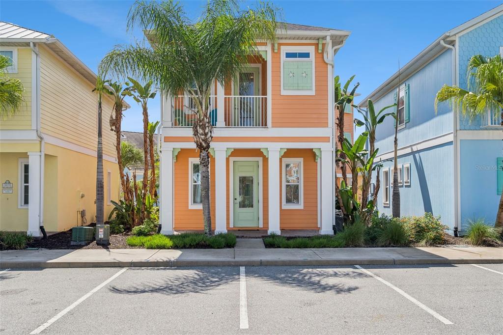 An aerial view shows a residential neighborhood with colorful houses, a lake, and a pool — 3071 KEY LIME LOOP, KISSIMMEE, FL