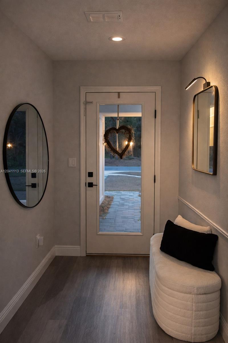 An entryway features a white door, two mirrors, and a curved bench with a pillow — 39 REDWOOD TRACK RUN, Ocala FL 34472, OCALA, FL