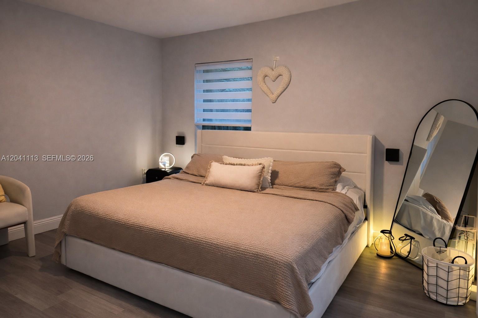 A bedroom features a white upholstered bed, a floor mirror, and a window with blinds — 39 REDWOOD TRACK RUN, Ocala FL 34472, OCALA, FL
