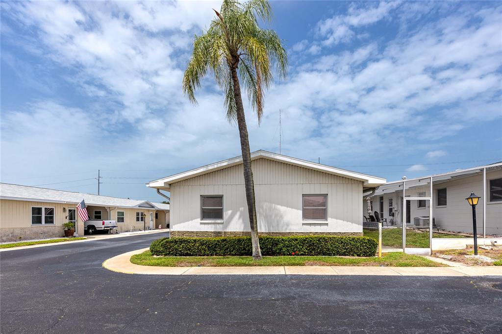 A single-story building with white siding and a palm tree in the front yard — 12400 PARK BOULEVARD UNIT 417, SEMINOLE, FL