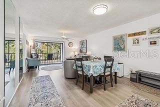 A dining area with a table and chairs sits next to a living room balcony — 104 E CYPRESS COURT UNIT 104, OLDSMAR, FL