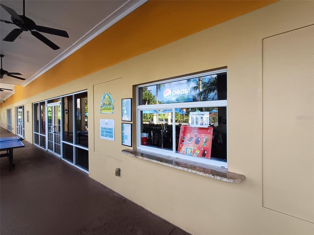 An outdoor concession stand window features a granite ledge and signage on a beige wall — 3005 RED GINGER ROAD, KISSIMMEE, FL