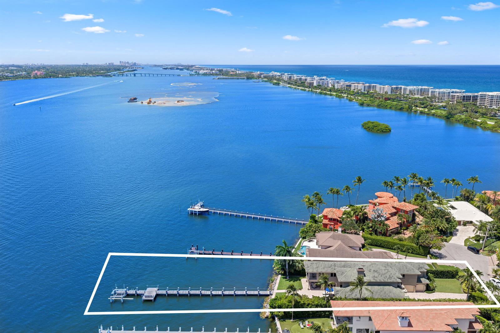 An aerial view shows a waterfront property with a private dock and a large house — 1207 N Atlantic Drive, Lantana FL 33462, LANTANA, FL