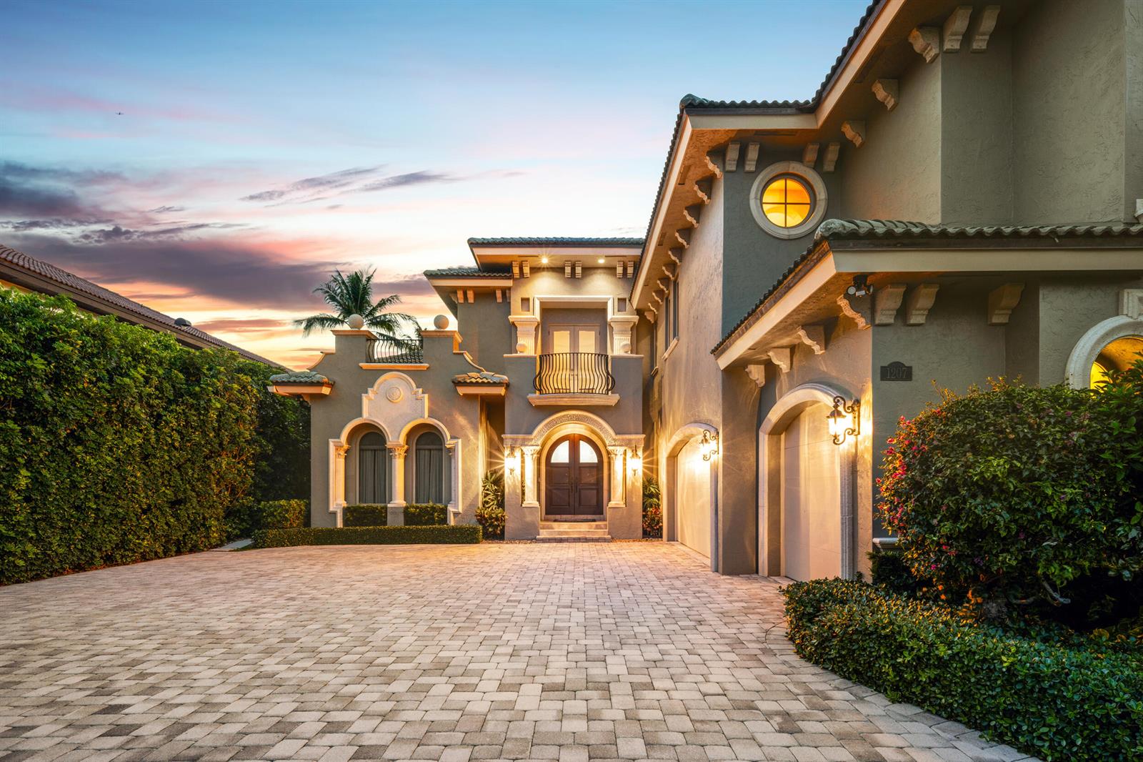 A two-story Mediterranean-style house with a paved driveway, arched entryway, and a circular window — 1207 N Atlantic Drive, Lantana FL 33462, LANTANA, FL