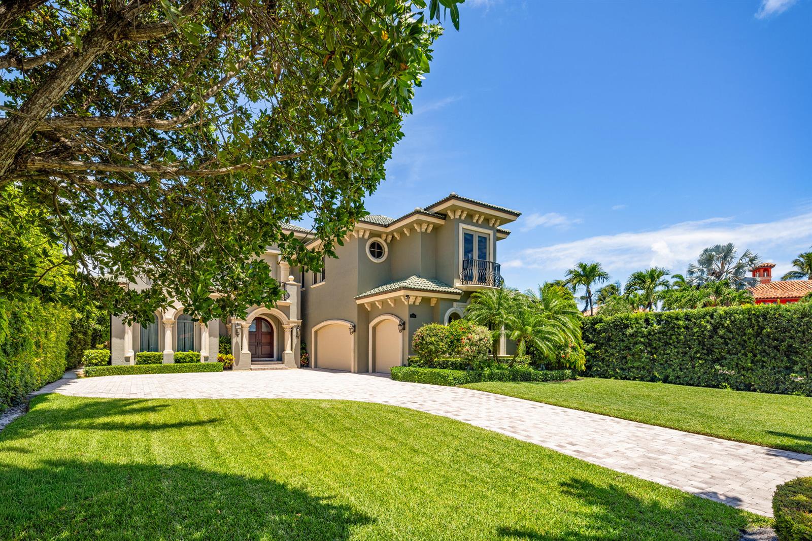 A two-story house with a paved driveway, manicured lawn, and a large tree in front — 1207 N Atlantic Drive, Lantana FL 33462, LANTANA, FL