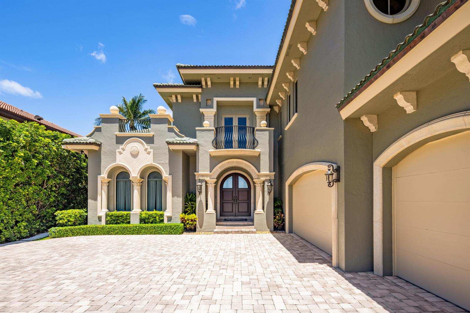 A two-story Mediterranean-style house features a paved driveway, arched windows, and a double-car garage — 1207 N Atlantic Drive, Lantana FL 33462, LANTANA, FL