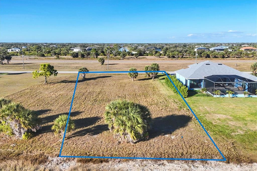 An aerial view shows a vacant, rectangular residential lot outlined in blue next to a house — 139 WREN DRIVE, PLACIDA, FL