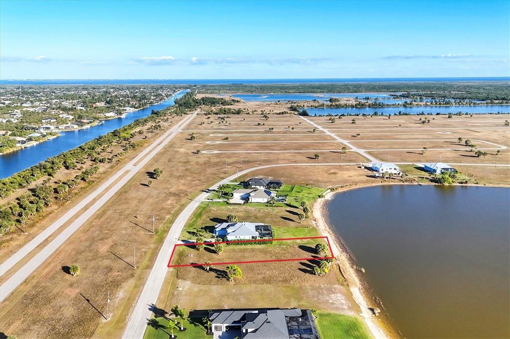 An aerial view shows a vacant rectangular waterfront lot outlined in red near a road — 139 WREN DRIVE, PLACIDA, FL