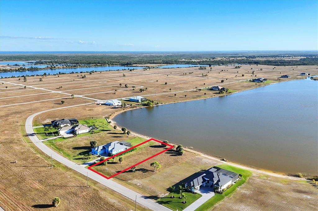 An aerial view shows a vacant waterfront lot outlined in red next to existing houses — 139 WREN DRIVE, PLACIDA, FL