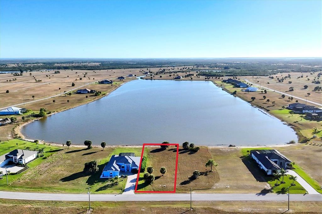 An aerial view shows a vacant waterfront lot outlined in red next to a house — 139 WREN DRIVE, PLACIDA, FL
