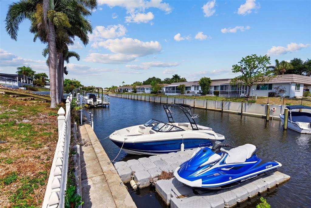 A boat and a personal watercraft are docked along a canal beside a residential property — 2555 CONSTITUTION BOULEVARD, SARASOTA, FL